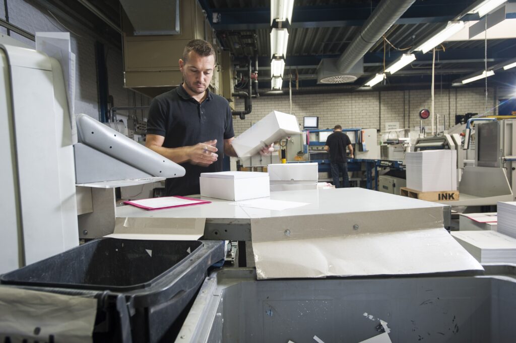 Employé préparant du papier pour une machine d’impression dans un atelier professionnel à Montréal