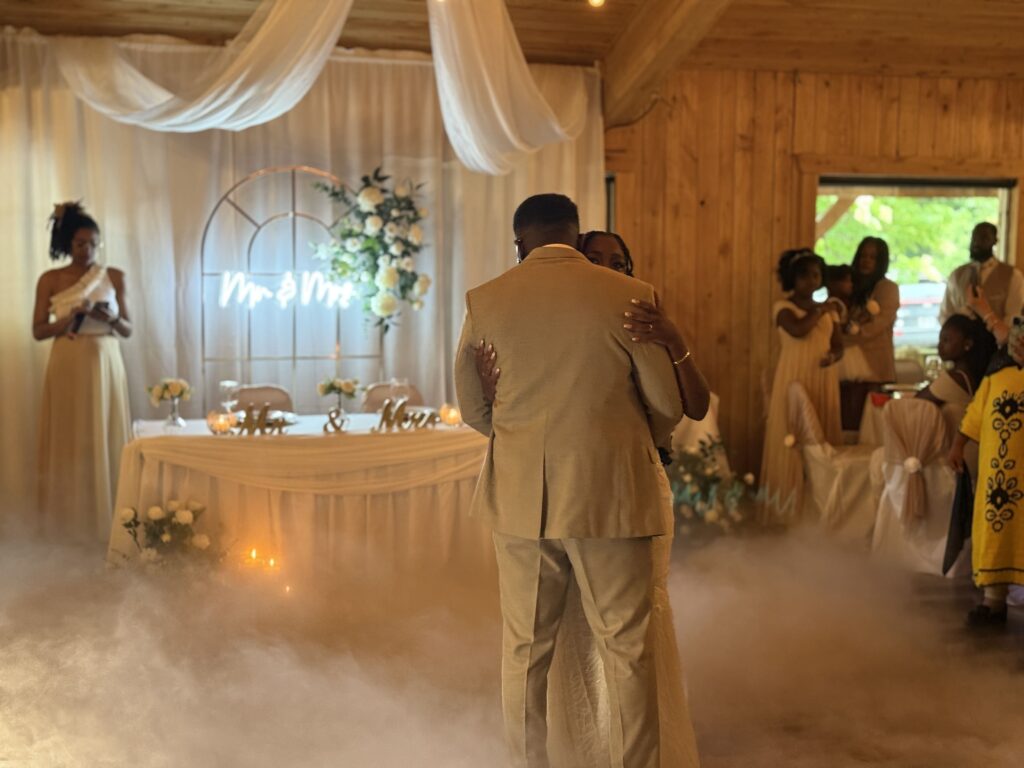 Couple africain dansant leur première danse dans un nuage de fumée, entouré de leurs proches, lors d’un mariage organisé et animé par NEK AGENCY à Montréal.